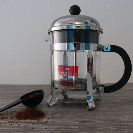 Load image into Gallery viewer, Bodum - Chambord French Press 4 Cup 500ml Glass Body with 4 Stainless steel Strips running Vertiacl up the French Press Body , Black Plastic Handle and Stainlesssteel Lid with Smll Black ball on top with Metal plunger with Small plastic Scoop - Velo Coffee Roasters
