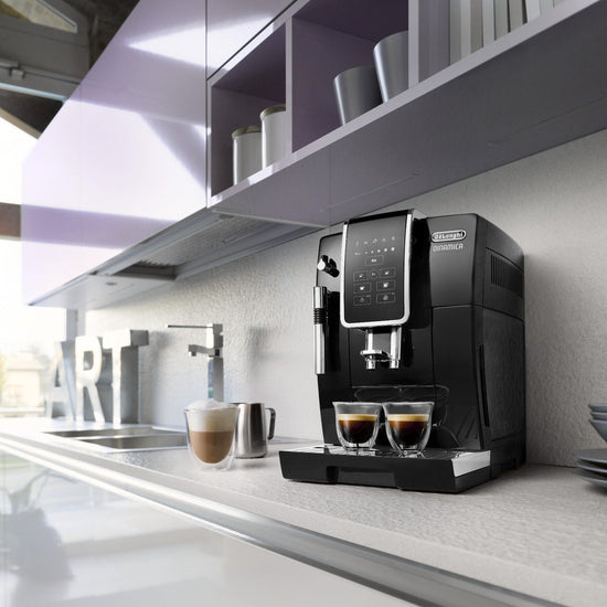 De'Longhi Dinamica - Bean To Cup Espresso Coffee Machine - Black - ECAM350.15.B - Black body with Stainless Steel elements with homescreen in front with bottonsVelo Coffee Roasters